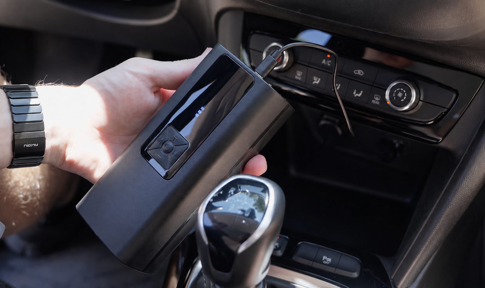 Compresseur TireHero rangé dans l'habitacle d'une voiture, format compact